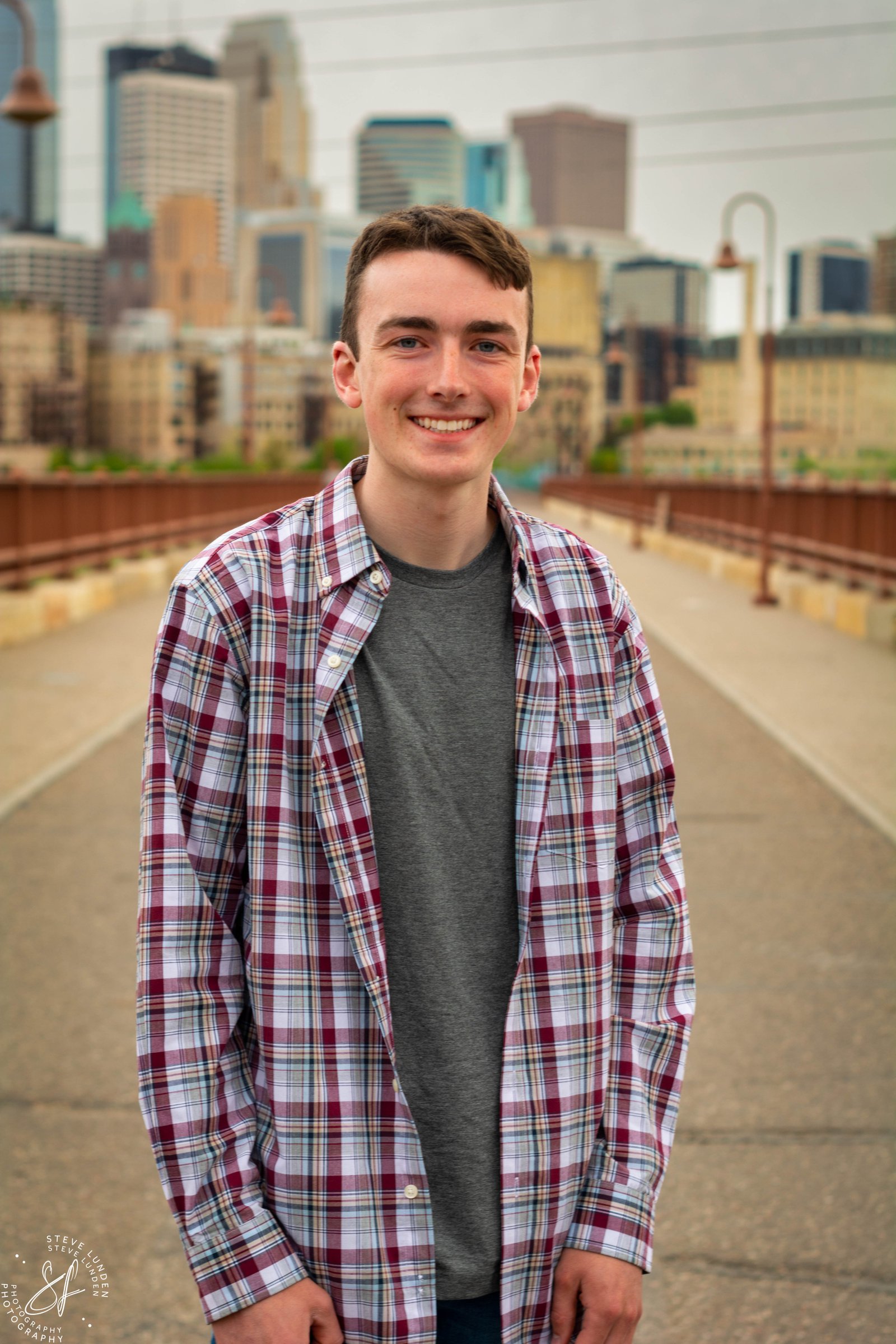 Minneapolis senior photos at the Stone Arch Bridge with the downtown skyline and Mississippi River