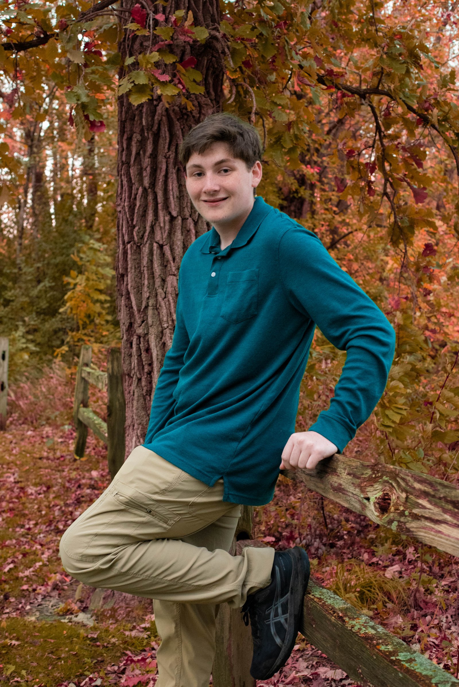 Senior posing against fence in autumn - fall senior portraits Coon Rapids MN