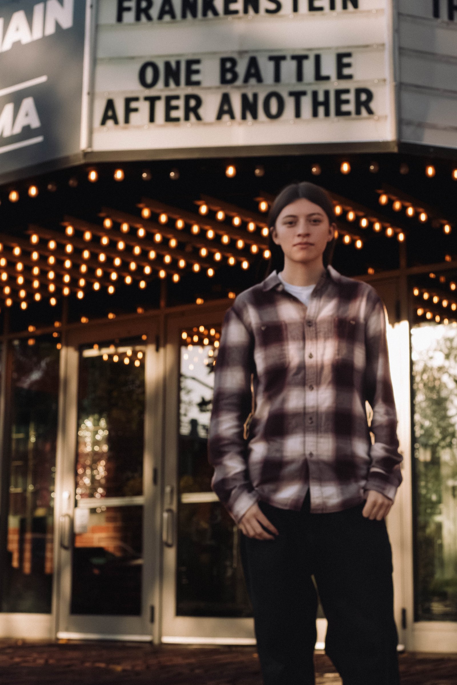 Senior posing in front of movie theater marquee - creative senior portraits Twin Cities